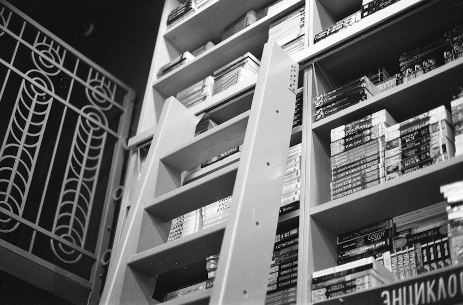 Monochrome image of a well-stocked bookshelf with Russian books and ladder.